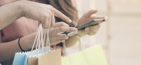 Banner illustrating a couple with mobile phone, turning points into pleasures with UOB Rewards